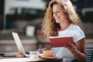 Junge Frau Kaffee lacht lernt Laptop Notizen