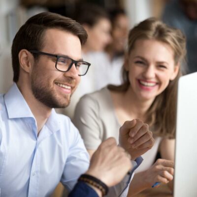 Mann und Frau lächelnd vor PC Mann und Frau lächelnd vor PC